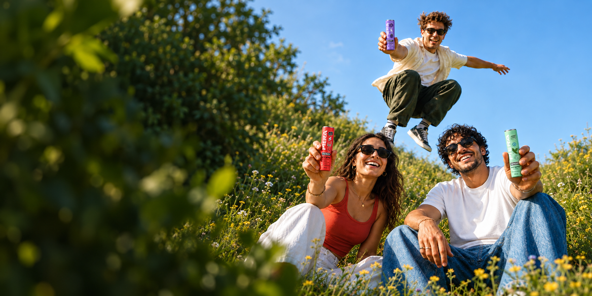 Three friends holding three PIERA oral spray flavors in a green meadow